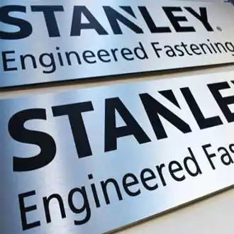 Two brushed silver dibond engineering firm signs on a table