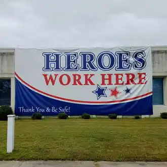 Vinyl banner on side of building reading Heroes Work Here