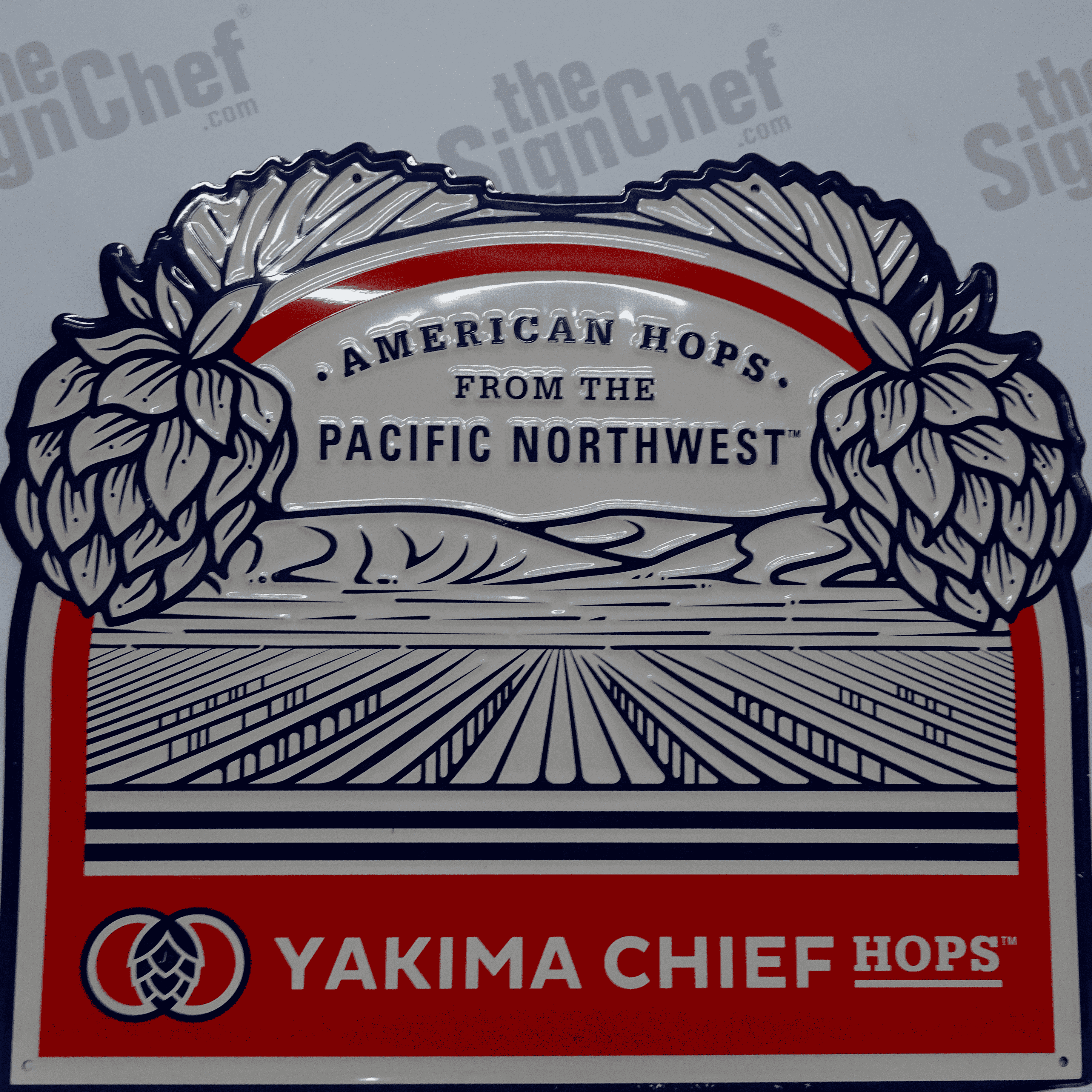 Orange, red, and white vintage sign with text that reads: Yakima Chief Hops